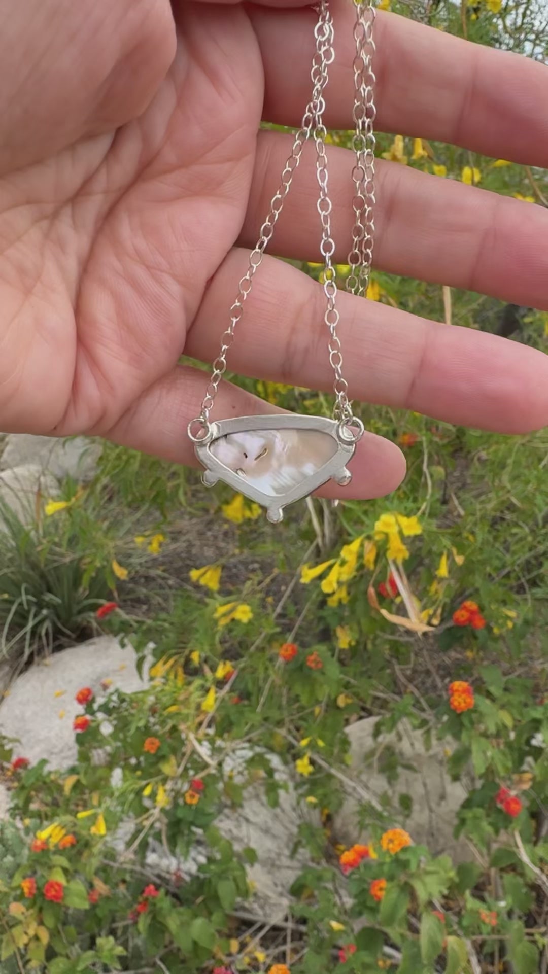 a handmade abalone shell necklace being twirled around