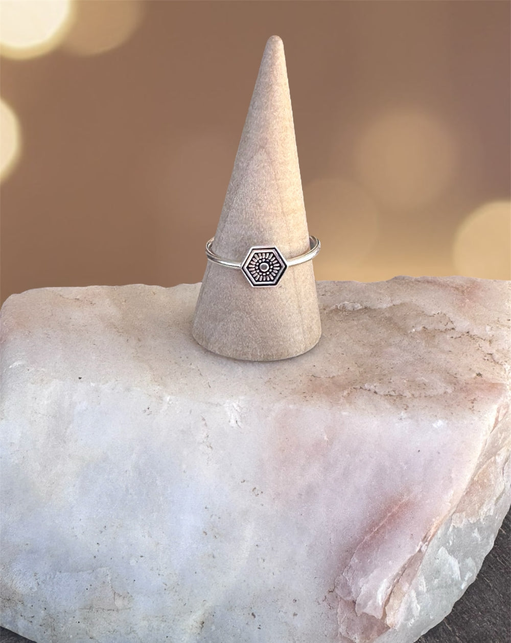 A handmade hexagon shaped stamped stacking ring made from sterling silver.