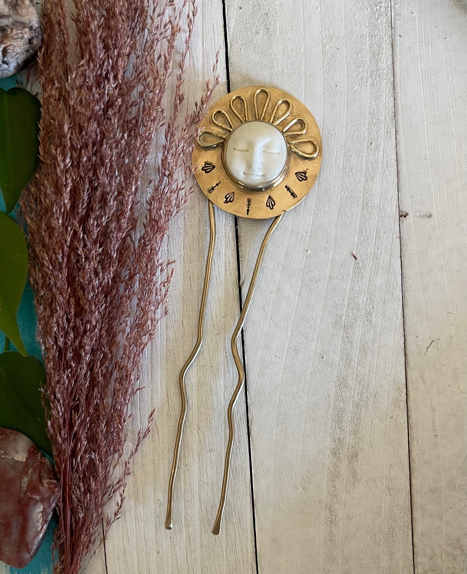 carved sun face stone sits in the center with brass sun rays. Hand stamped. brass hair fork