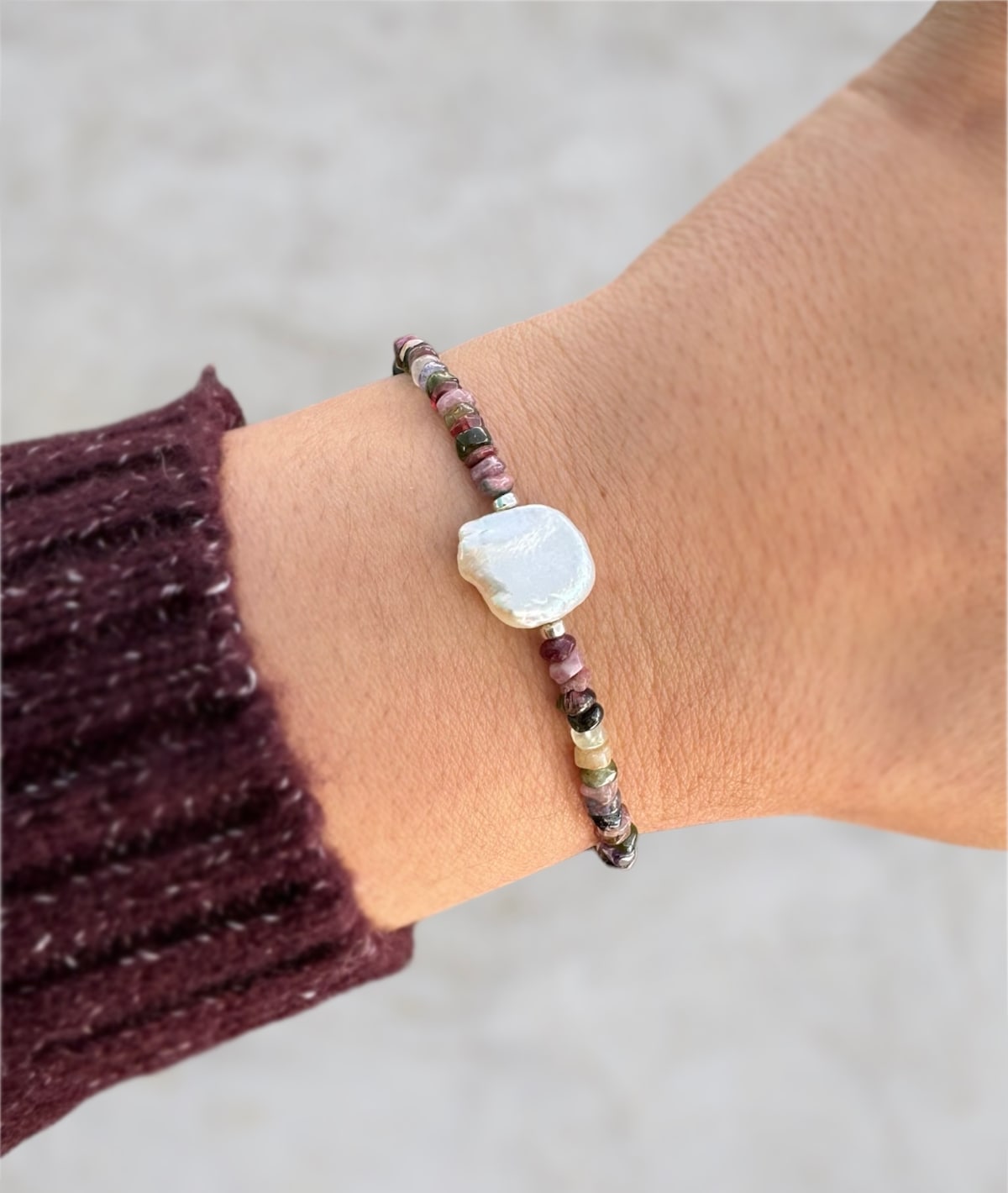 Tourmaline gemstone and pearl bracelet worn on wrist