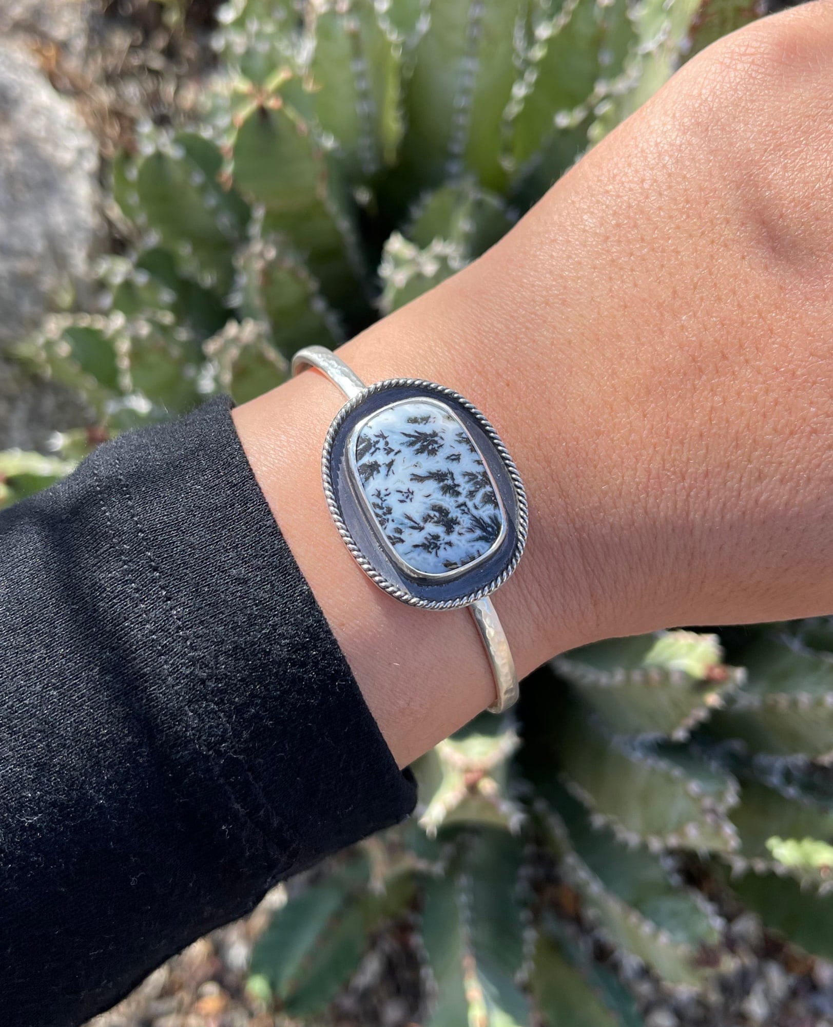 black and white dendritic agate stone with sterling bead wire on hammered cuff bracelet worn on wrist