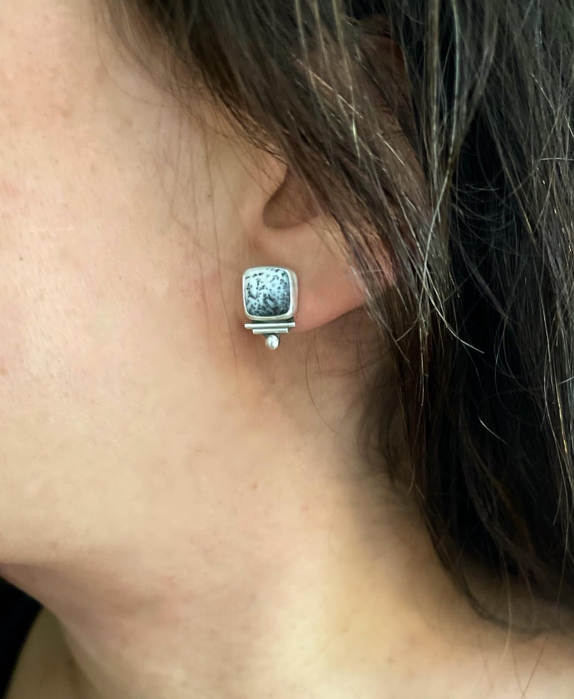 black and white dendritic agate square stone stud earrings, with sterling silver embellishments shown worn in ear