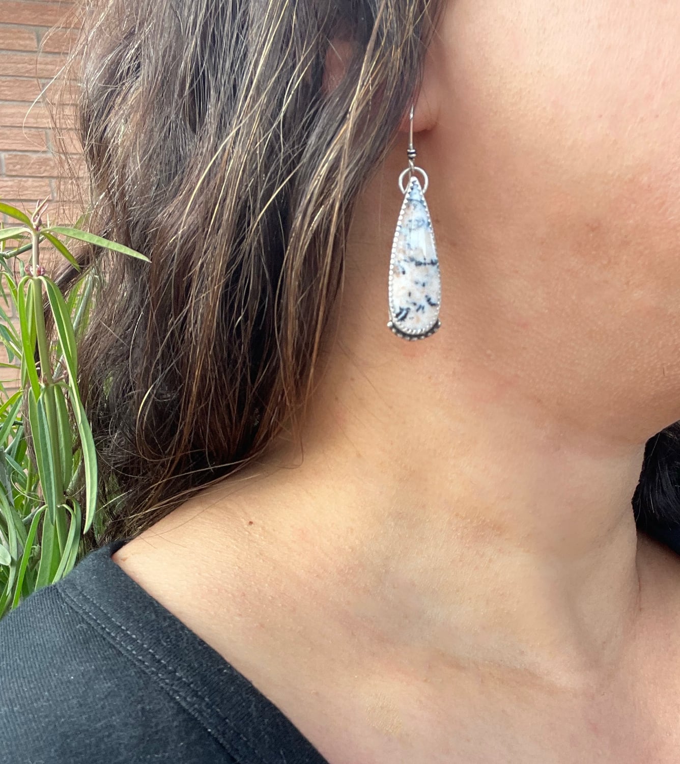 dendritic agate teardrop shaped earrings with bead wire accents and sterling silver ear wires shown worn