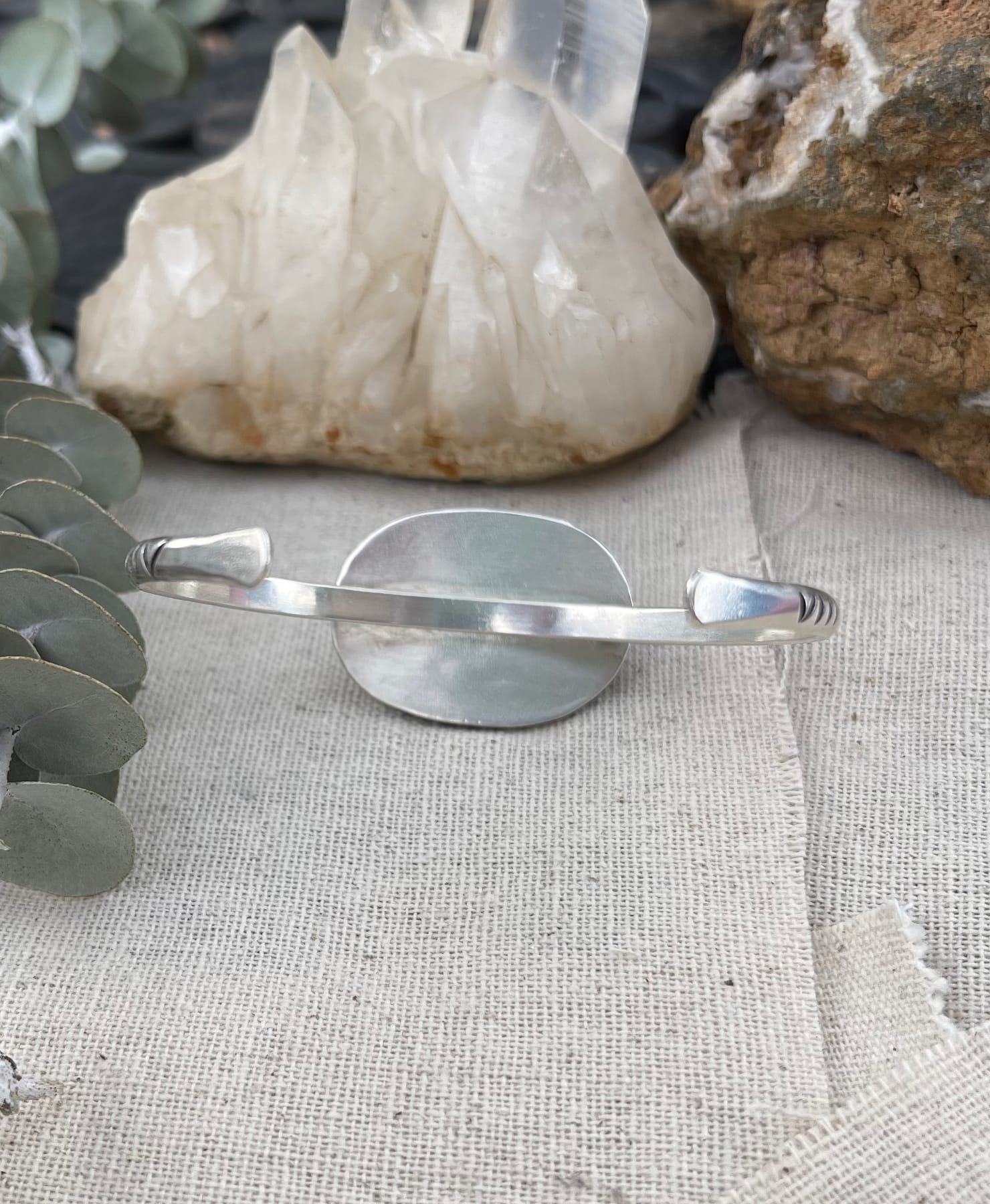 back view of sterling silver cuff bracelet with a round dendritic opal stone with sterling bead wire around it