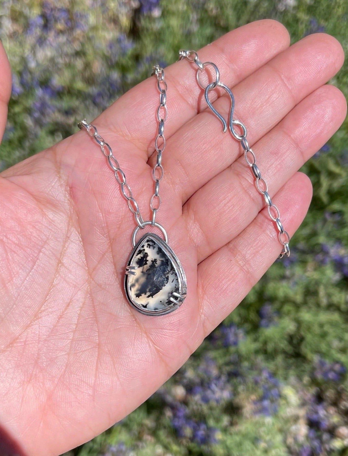 dendritic opal teardrop shaped necklace with easy s hook clasp shown in natural sunlight