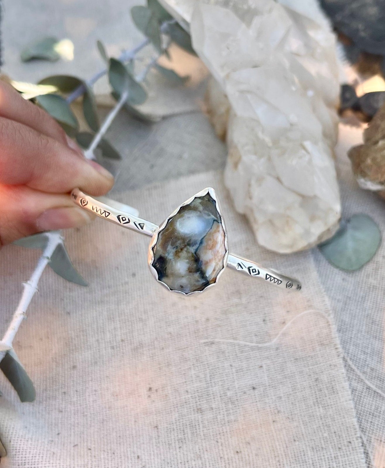 sterling silver handstamped cuff bracelet with a big teardrop shaped jasper stone in a scalloped edge bezel