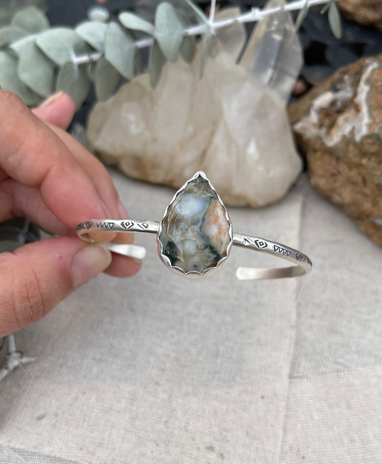 sterling silver handstamped cuff bracelet with a big teardrop shaped jasper stone in a scalloped edge bezel