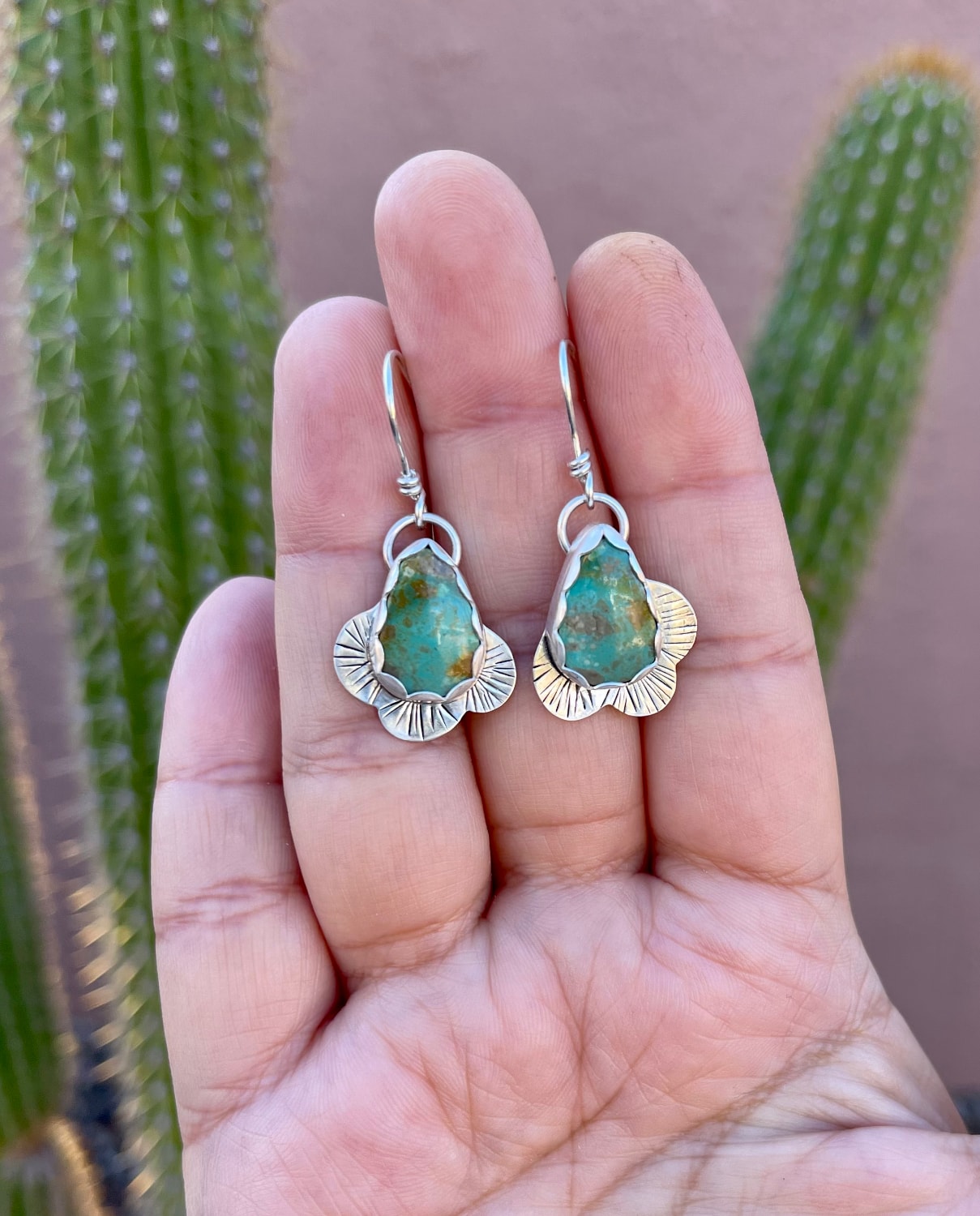 Kingman teardrop shaped turquoise stones with sterling silver curvy line stamped border dangly earrings with sterling ear wires