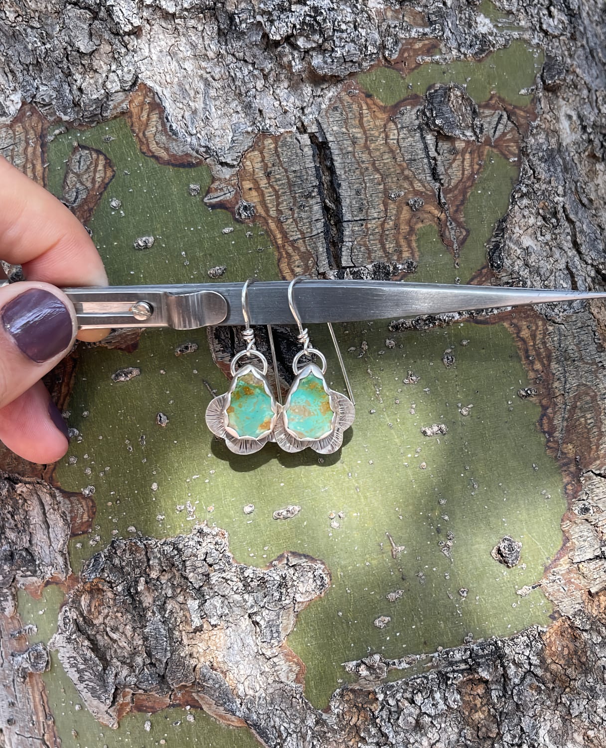 Kingman teardrop shaped turquoise stones with curvy silver line stamped edge dangly earrings